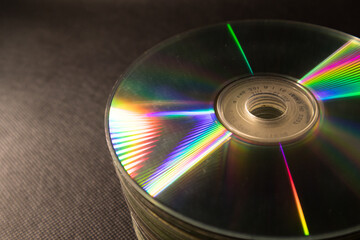 Old CDs/DVDs are stacked in black background