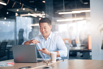 Asian businessman communicating in video call with deaf client at her workplace in modern office