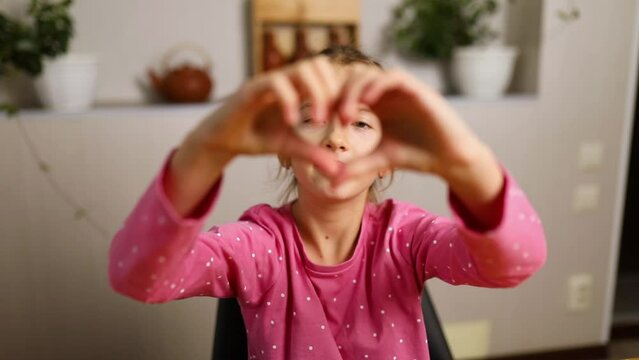 Little girl, making hearts from hands, love, casual cheerful cute funny girl showing heart shape sign with fingers