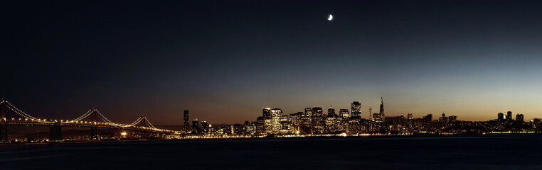 the skyline of San Francisco with the bay bridge at night
