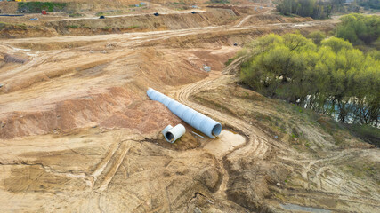 Concrete sewer pipes for laying external sewage system at construction site. Storm sewer collector...