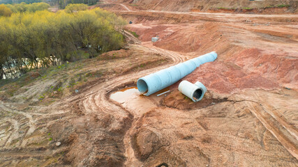 Concrete sewer pipes for laying external sewage system at construction site. Storm sewer collector...