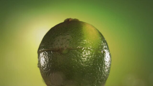 Half Lime falling and splashing on green background. Food levitation concept. Slow Motion