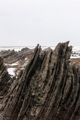 Fototapeta na wymiar stratified rocks on the beach of sopelana in the basque country