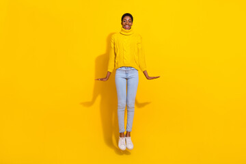 Full length body size view of attractive cheerful funky slender skinny girl jumping up isolated over bright yellow color background