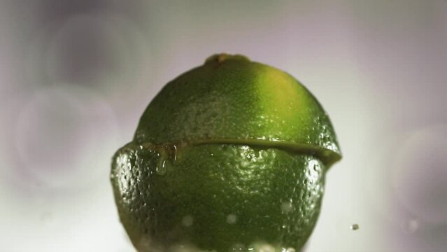 Half Lime falling and splashing on white background. Food levitation concept. Slow Motion