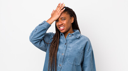 afro pretty woman raising palm to forehead thinking oops, after making a stupid mistake or...