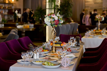 tableware Glasses, flower fork, knife served for dinner in restaurant with cozy interior