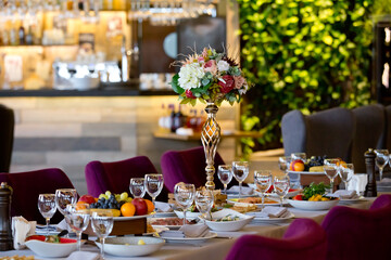 tableware Glasses, flower fork, knife served for dinner in restaurant with cozy interior