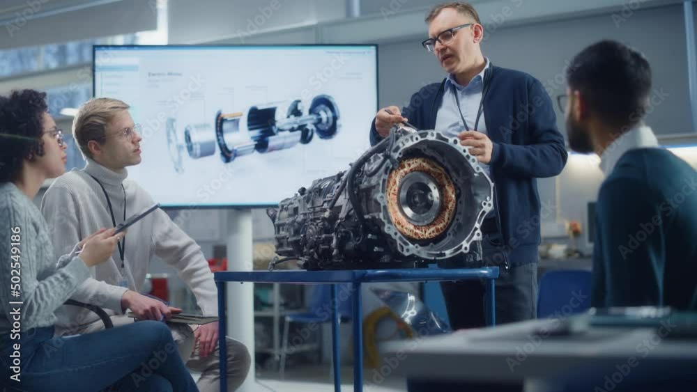 Aufkleber innovative green energy startup: male engineer talks to young specialists about engine using big scr