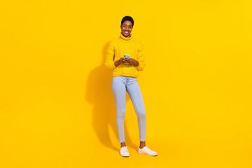 Fototapeta na wymiar Full length body size view of attractive cheerful skinny girl using device smm 5g app post isolated over bright yellow color background