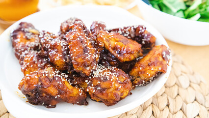 Fried chicken with spicy Korean sauce, rich with sesame seeds.