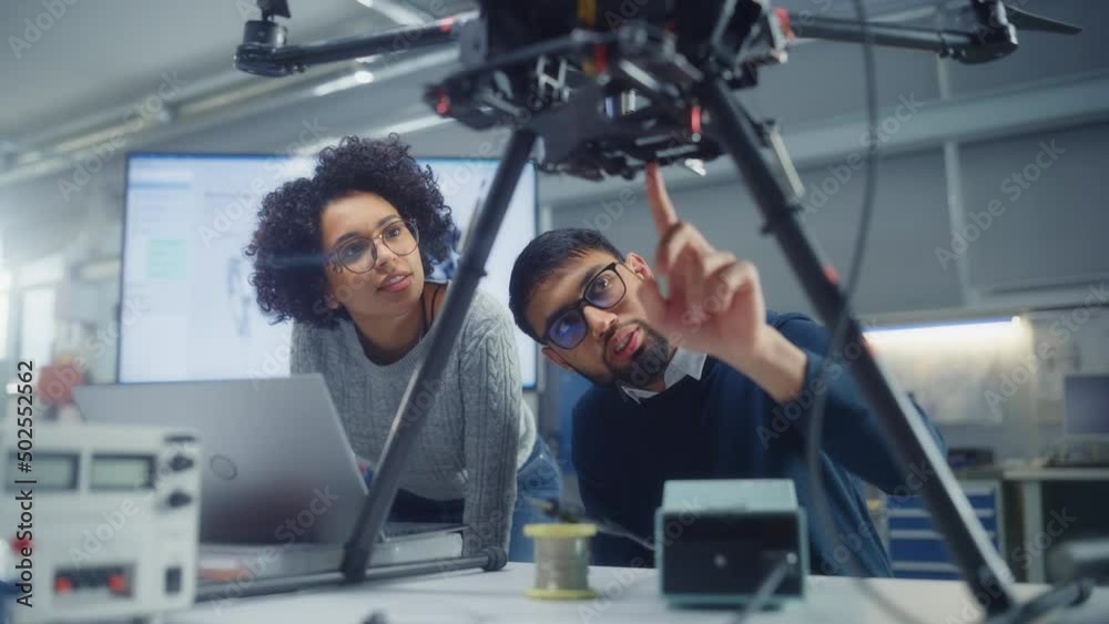 Poster black male engineer put at laptop screen and talk while brainstorming with his female colleague abou