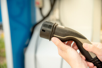 woman holding electric charger head for electric car.EV car charger.
