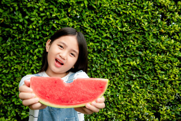 Smiling girl having enjoy eating watermelon in summer