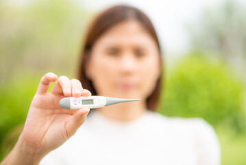 Woman hand holding a thermometer Equipment needed to measure fever During the COVID epidemic