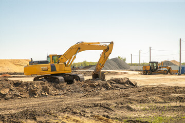 Obraz premium Crawler excavator, big yellow construction excavator at the construction site in a quarrying quarry. Industrial image.