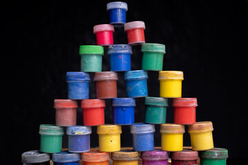 pyramid of gouache paints on isolated black background