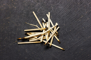 Burnt matches on a black background. Collection of charred matches.