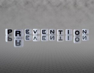 prevention word or concept represented by black and white letter cubes on a grey horizon background stretching to infinity