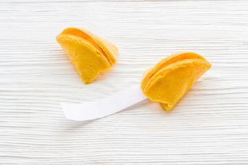 Broken Chinese fortune cookie with blank slip outside