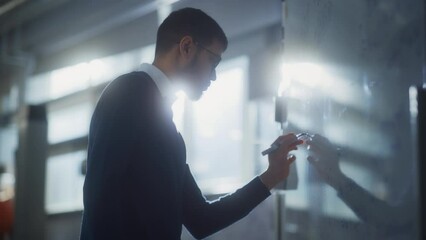 Concentrated Male Scientist Drawing Formulas and Elements on the Whiteboard. Searching New Strategies at Engineering Concept. Portrait Shot