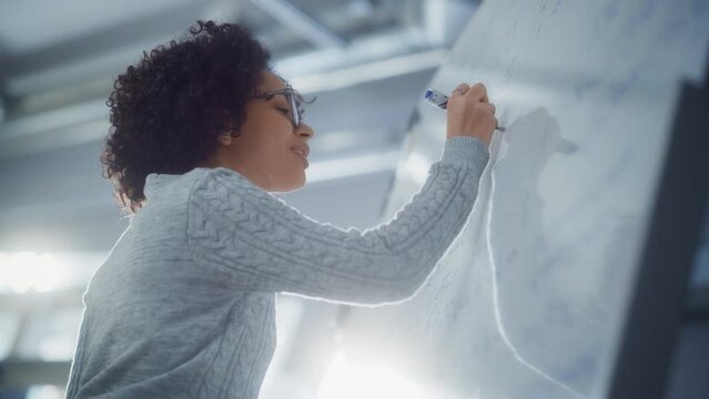 Happy Female Student Thinking about Solving Math Equation in front of Whiteboard. Education, Learning and Startup Concept. Slow Motion