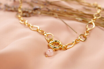 Made of rose quartz stone with a gold chain and lock.