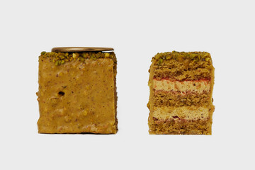 Front view macro image of two pieces of medovik cake with honey decorated with nuts isolated at white background.