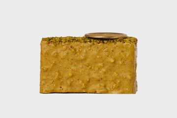 Front view macro image of  medovik piece of cake with honey decorated with nuts isolated at white background.