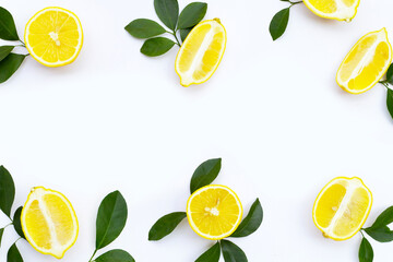 Frame made of fresh lemon with green leaves on white background. Top view
