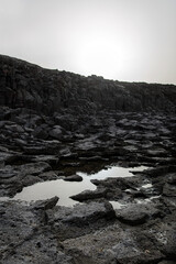 Volcanic landscape. Cooled lava is black rocky texture.