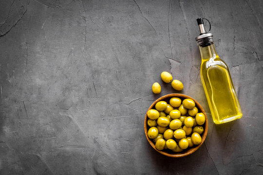 Olive oil in bottle with green olives. Cooking oil background