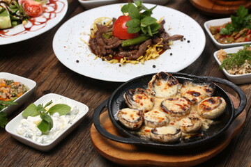 appetizers next to red meat on french fries on white plate