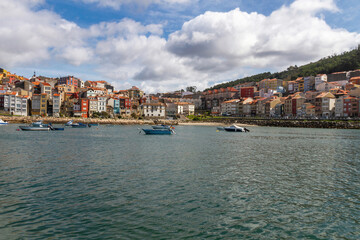 View of the town of La Guardia (A Guarda) in front of the port with boats in the water. Galicia. Spain