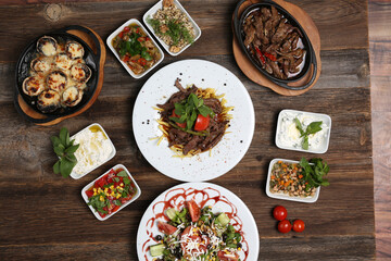 appetizers next to red meat on french fries on white plate