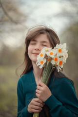 Naklejka premium A beautiful girl with a bouquet of daffodils.