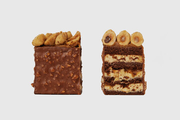 Front view image of two slices of chocolate cake decorated with nuts isolated at white background.