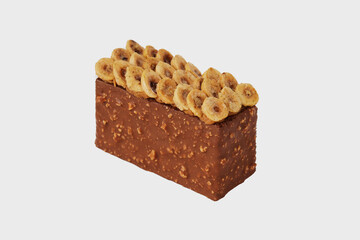 Closeup image of sweet piece of chocolate cake decorated with nuts isolated at white background.