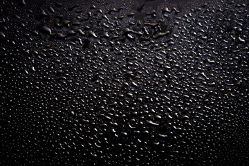 Black abstract background with water drops. Wet black texture.