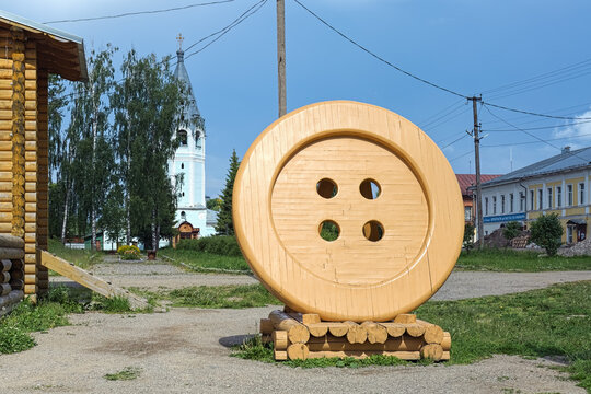 Chukhloma, Russia. Button Monument and Church of the Dormition of the Mother of God in the background. The wooden button with a diameter of 3 meters was installed in 2017.