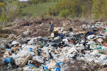 A view of the landfill. Garbage dump. A pile of plastic rubbish, food waste and other rubbish. Pollution concept. A sea of garbage starts to invade and destroy a beautiful countryside scenery