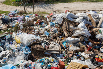 A view of the landfill. Garbage dump. A pile of plastic rubbish, food waste and other rubbish. Pollution concept. A sea of garbage starts to invade and destroy a beautiful countryside scenery