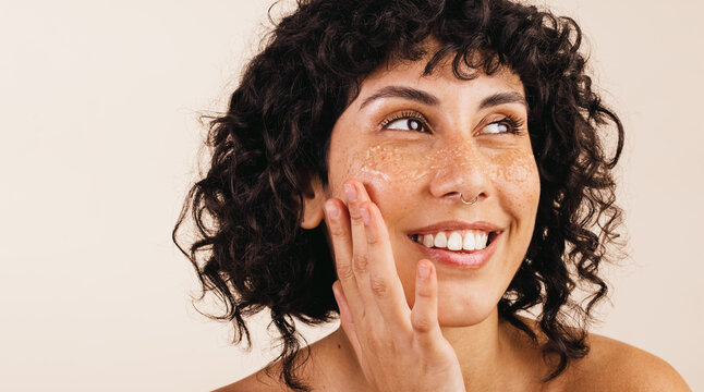 Young Woman Cleansing Her Face With A Scrub