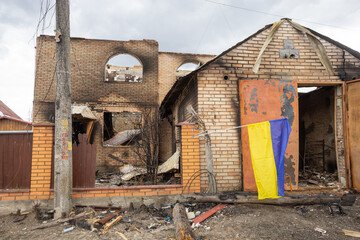 Shelled house with Ukrainian flag.