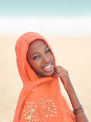 Beautiful young woman smiling and wearing an orange headscarf on a celebration day, photo - obrazy, fototapety, plakaty