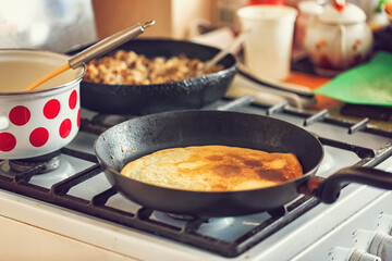 Cooking pancakes with meat filling in old kitchen in village