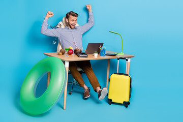 Full size photo of excited emotion yelling guy raise fists in victory win vacation tour isolated on blue color background
