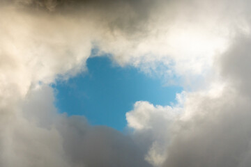 Fototapeta na wymiar Blue sky behind dark storm clouds background texture, thunderstorm