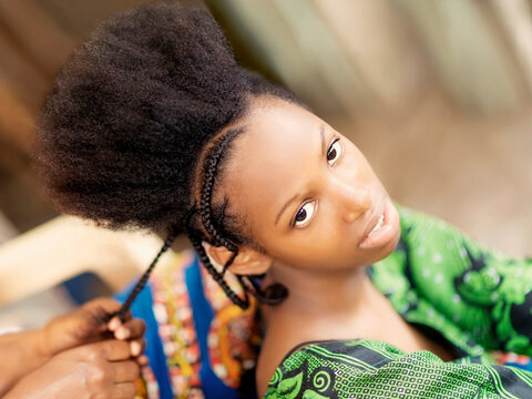 Young afro beauty being braided, eighteen years old